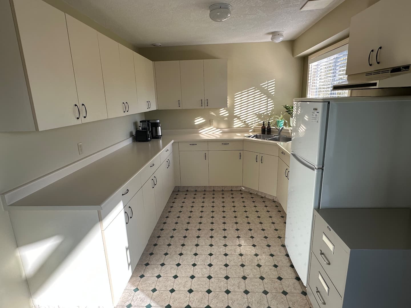 Kitchenette with fridge, counters and plenty of storage